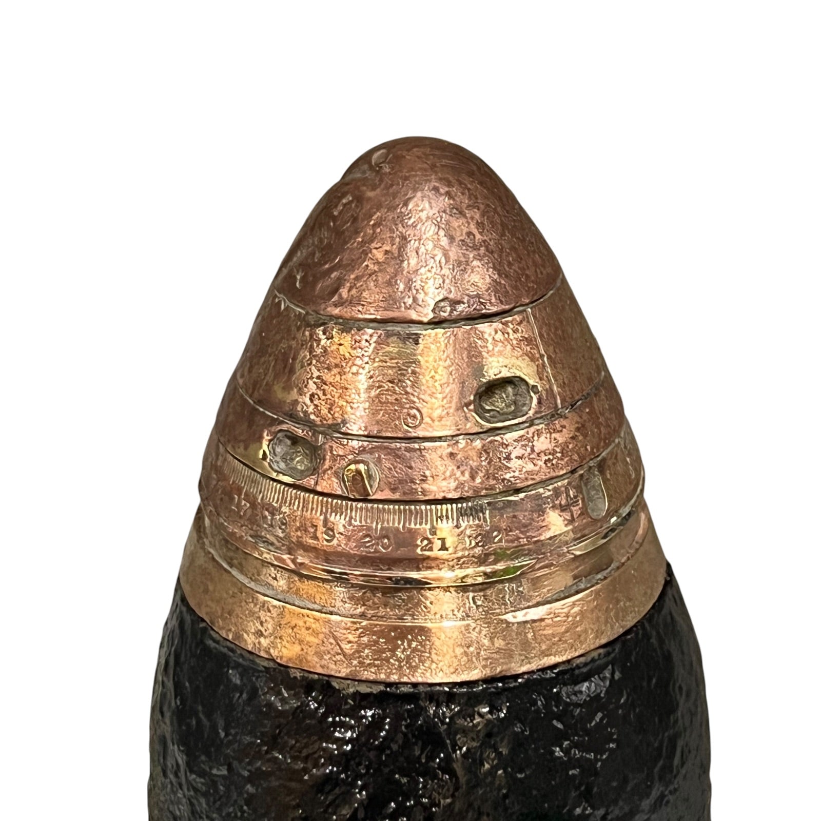 A close up of a WW1 18 pounder consisting of a brass shell, iron shrapnel and brass fuse on a white background 