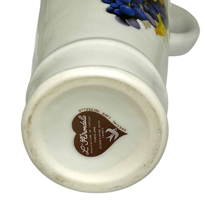 Close-up of a porcelain bottle with a brand logo on the base against a white background