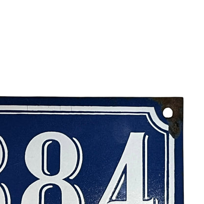 Close-up of a blue metal sign with white text on a white background