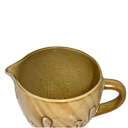 Close up of ceramic pitcher with 'eau fraiche' text on a white background