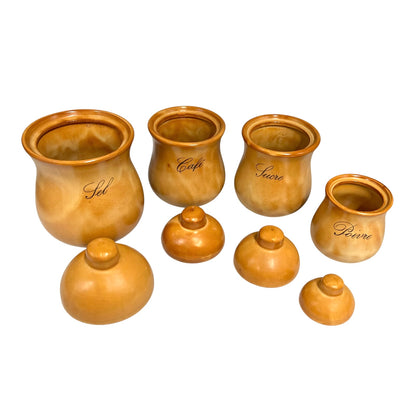 A set of 4 glazed ceramic canisters and jars with matching lids, arranged on a plain white background. The canisters are in various sizes and are individually labelled with cursive script words including 'Sel', 'Café', 'Sucre', and 'Poivre'.