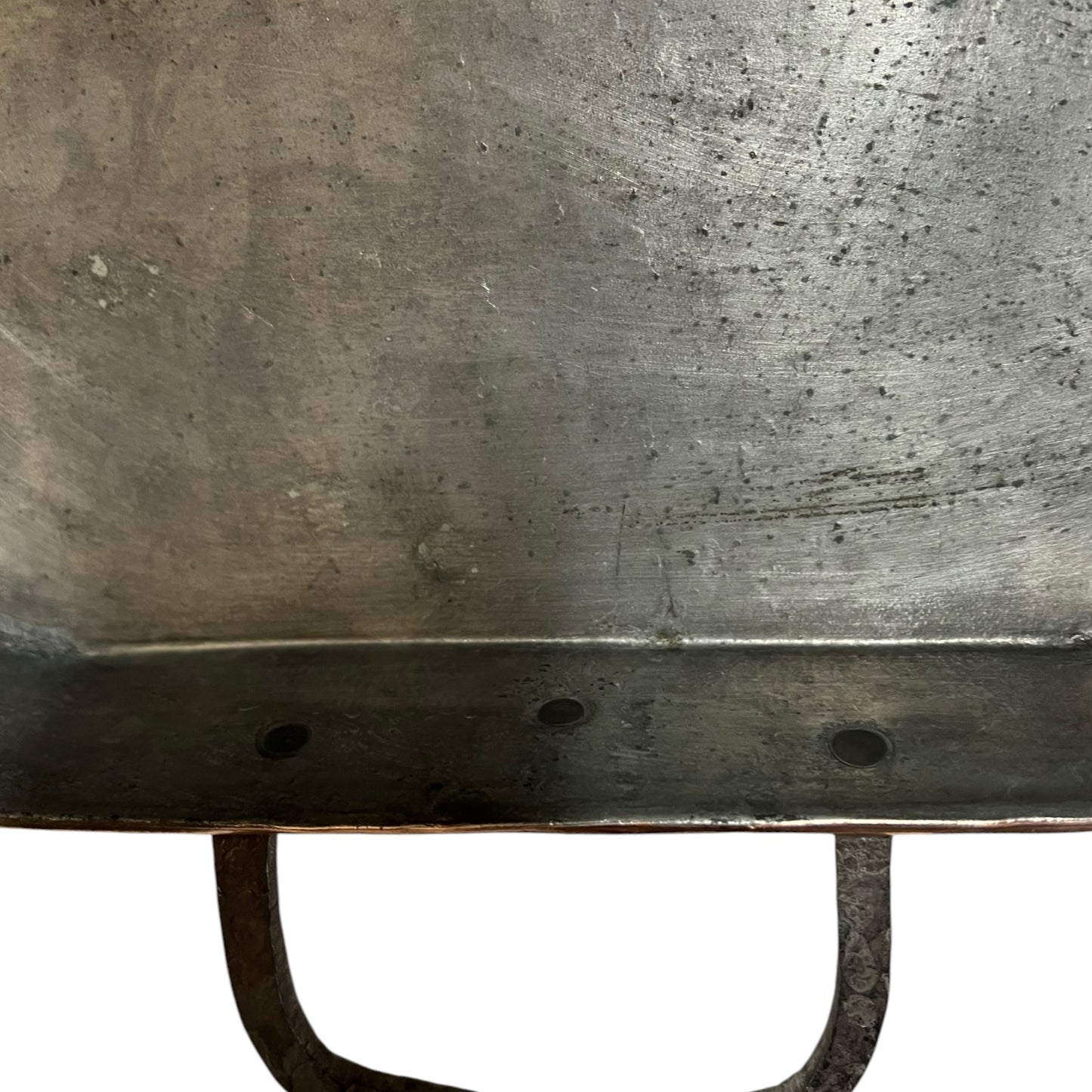 Close up of a copper roasting pan with a long handle on a white background