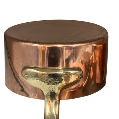 Close-up of a copper pot with a brass handle on a white background