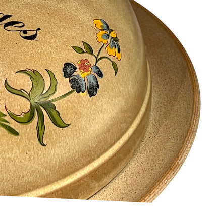 Beige ceramic plate with floral designs on a white background