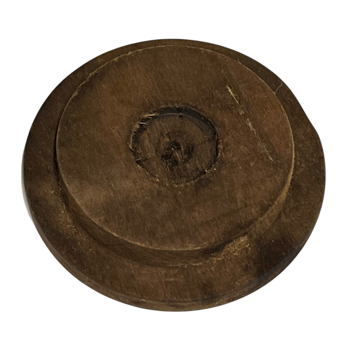 A round, dark brown wooden object with concentric circular grooves and a textured, weathered finish, isolated on a white background.