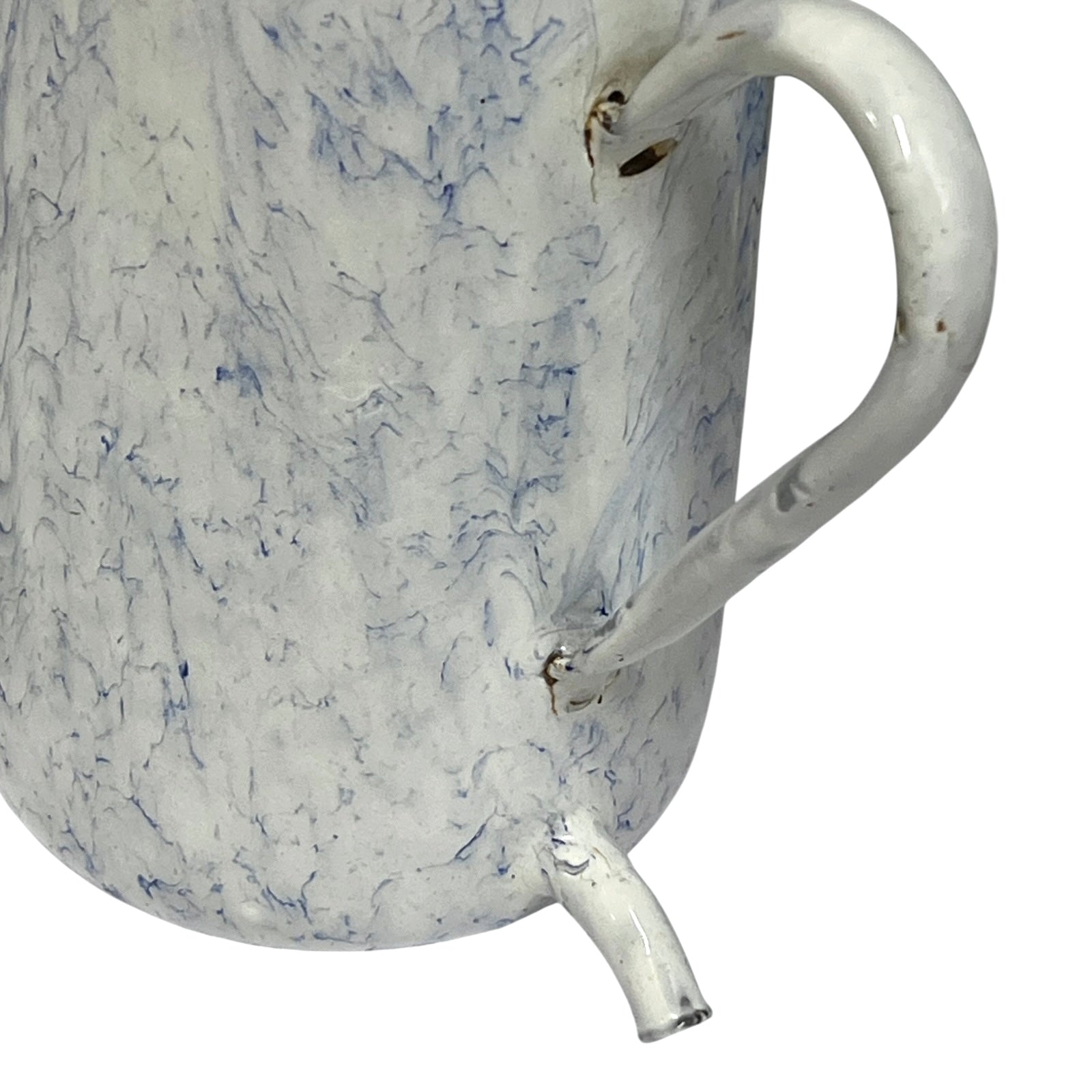 Close-up of a white enamel pitcher with a blue marbled pattern and a curved handle, shown on a white background.