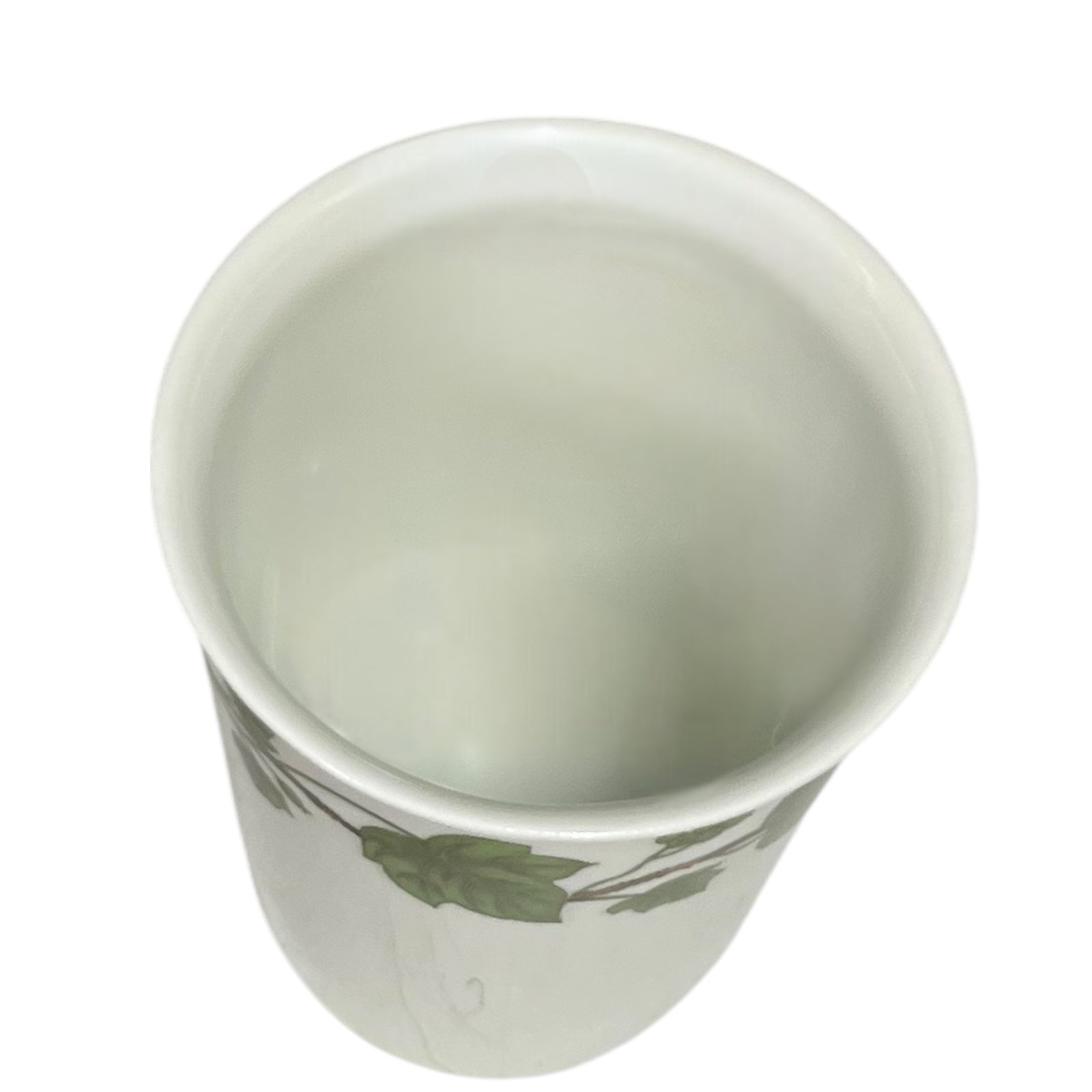 Porcelain bathroom tumbler  featuring green leaf patterns on a white background
