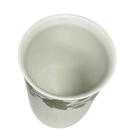 Porcelain bathroom tumbler  featuring green leaf patterns on a white background