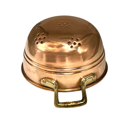 A copper colander with a domed lid featuring multiple drainage holes and two brass-handles on the sides, shown against a plain white background.