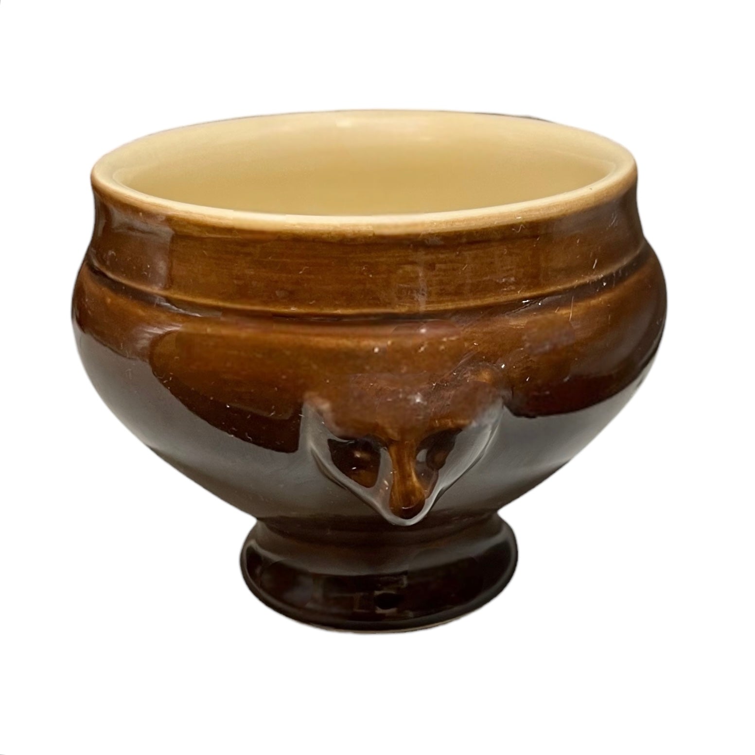 Brown ceramic bowl with decorative lion head handles on a white background