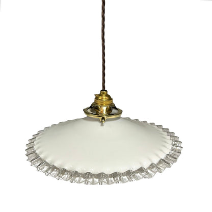 A vintage-style pendant light with a white glass shade featuring a fluted, ruffled edge and a polished brass metal fixture, suspended from a dark brown cord against a plain white background.