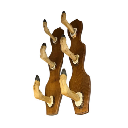 Two wooden wall hooks with deer hoof designs on a white background