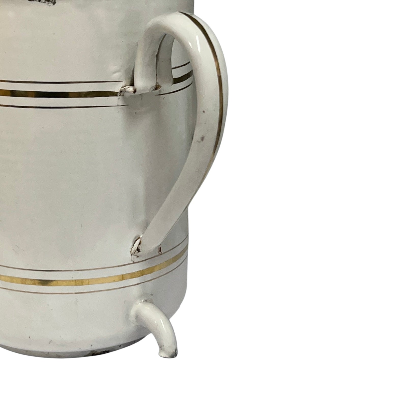 A close-up of a white ceramic pitcher or mug with a curved handle, a small spout, and thin gold decorative stripes on a white background.