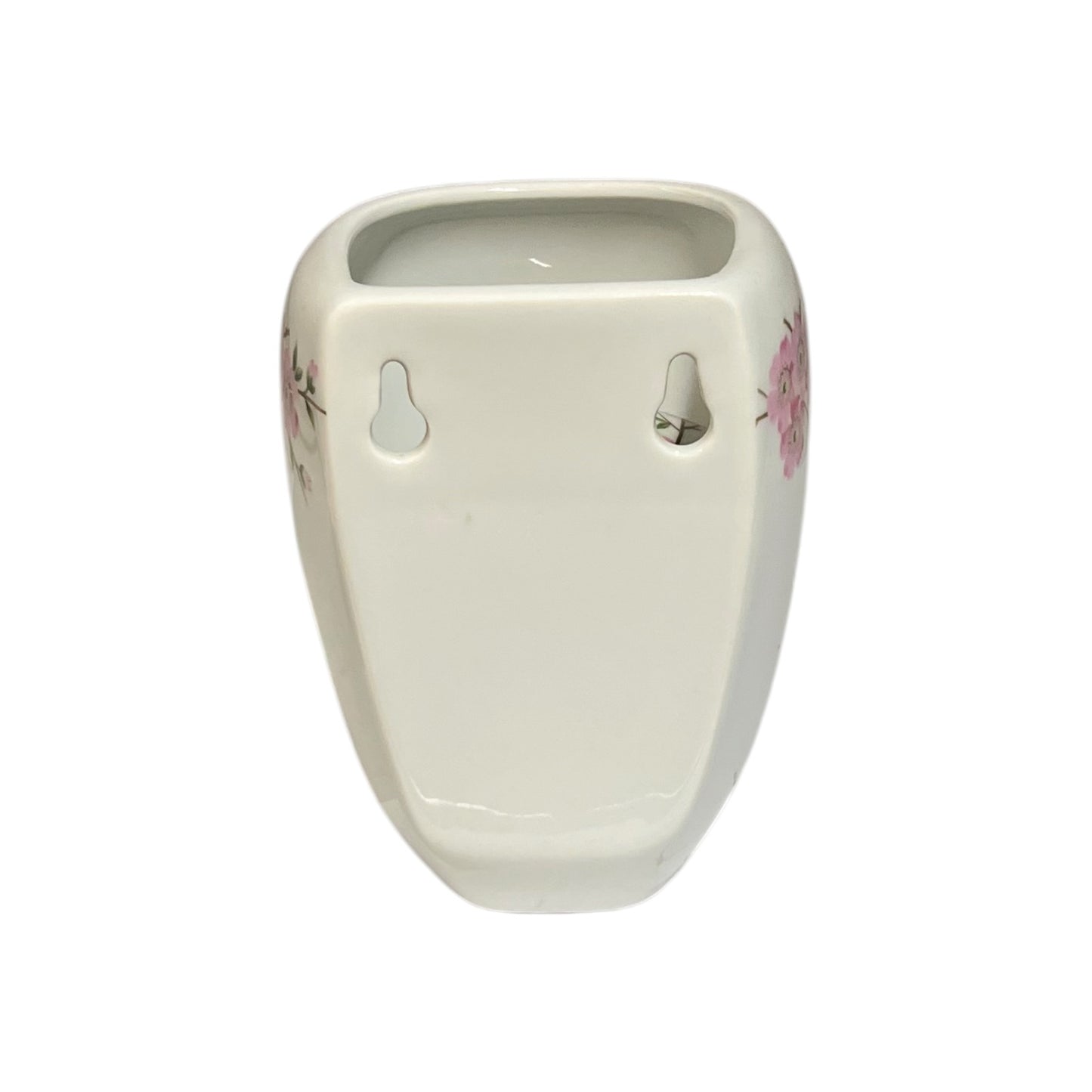 An off-white ceramic toothbrush holder with pink floral accents on the sides, shown against a plain white background.