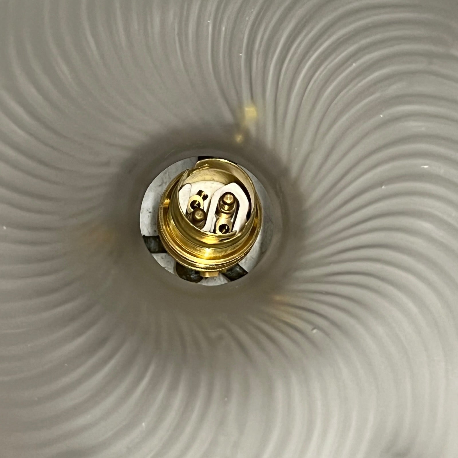 Close up of a vintage glass lampshade and brass fittings