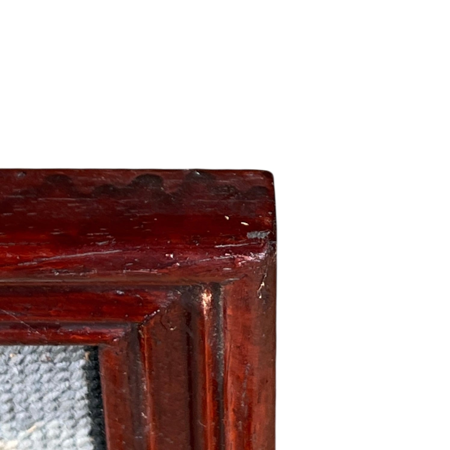 Close up of framed tapestry needlepoint with a coastal scene and wooden frame on a white background