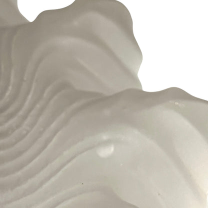 Close up of a glass lampshade and brass fittings on a white background
