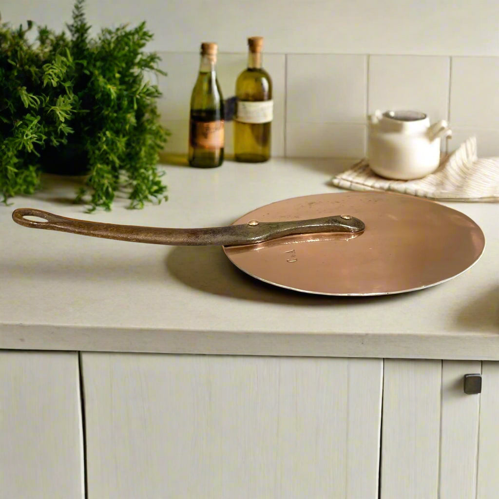 Antique Universal Fit Flat Copper Pan Lid with a cast iron handle and copper rivets