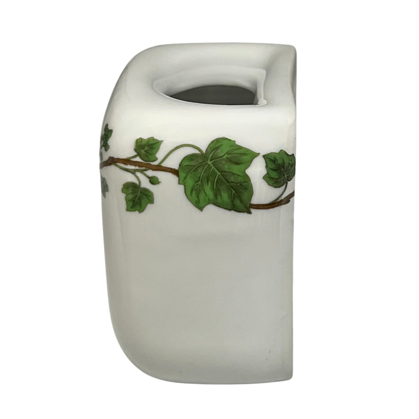 White ceramic toothbrush pot with green leaf design on a white background