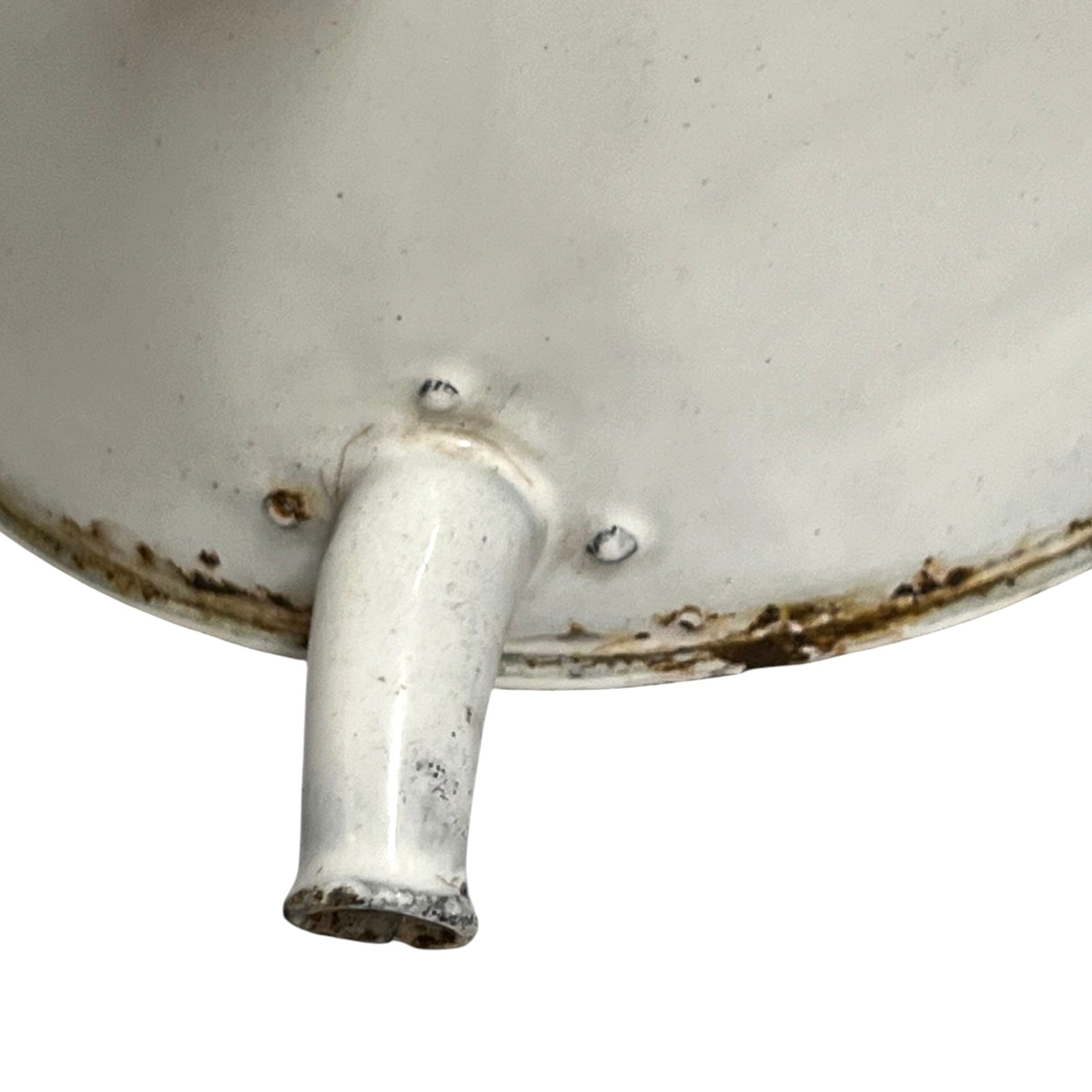 Close-up of the bottom interior of a white enamel or porcelain vessel with a protruding spout or handle, showing worn brown rust-like staining around the rim and base.