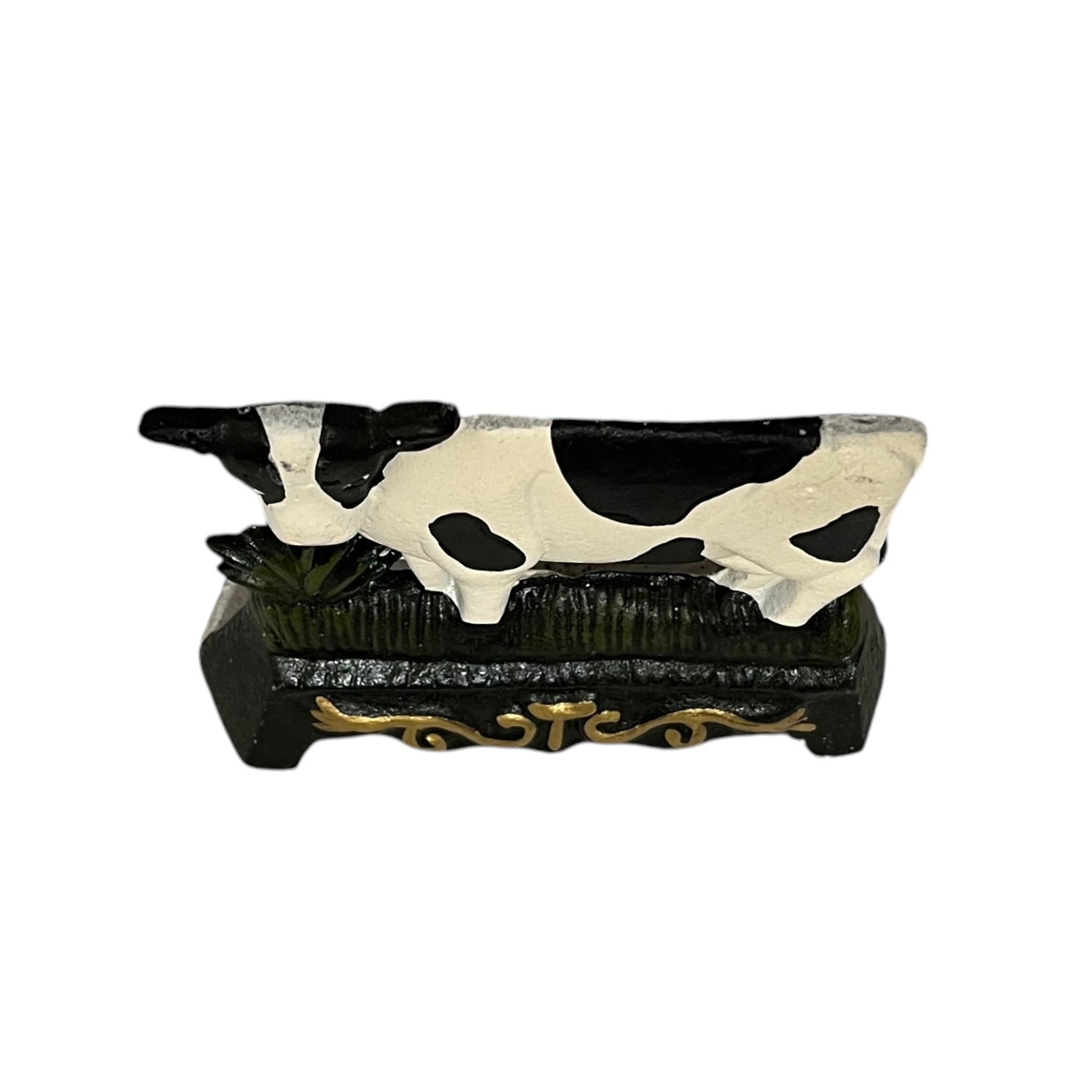Close up of small cow shaped cast iron doorstop on a white background