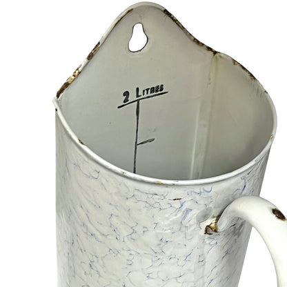 A vintage white enamel shower caddy with a marbled crackle pattern, featuring a hanging loop, a handle, and '2 Litres' printed inside.