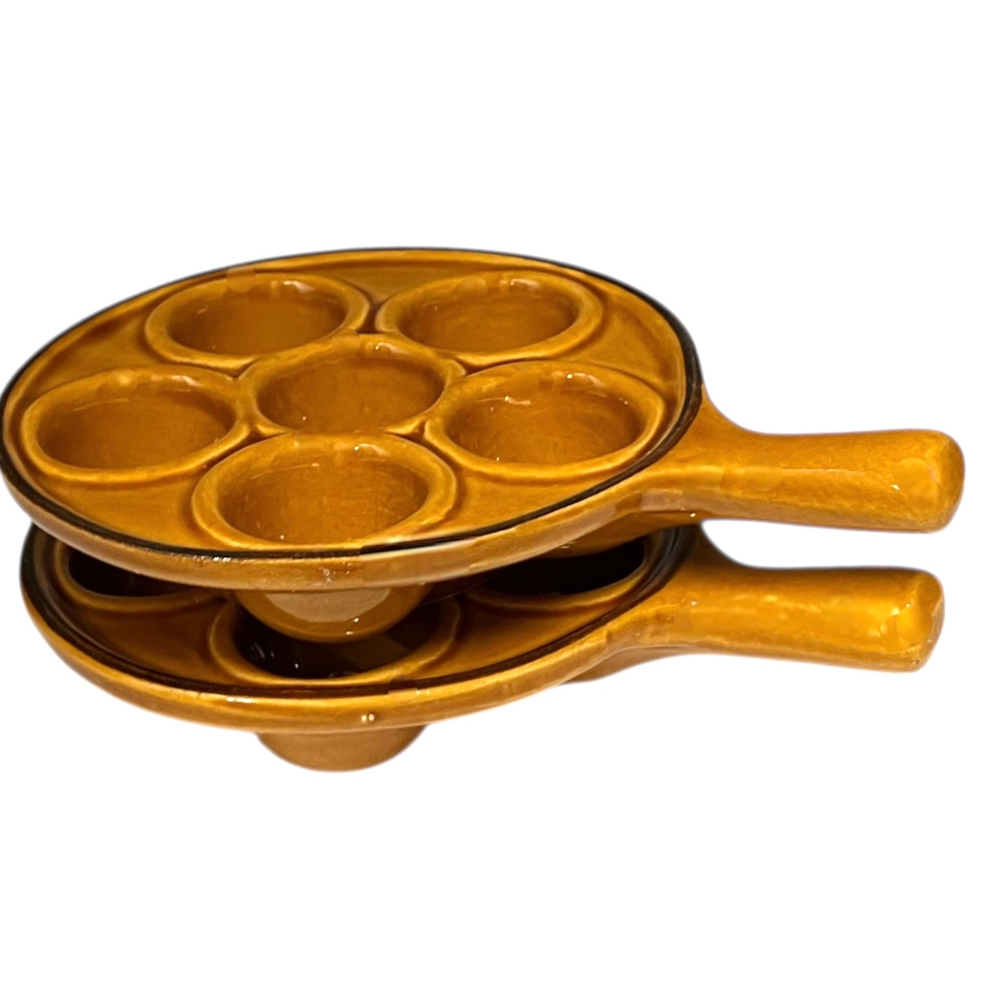 pair of amber-coloured French ceramic escargots plates with handles on a white background