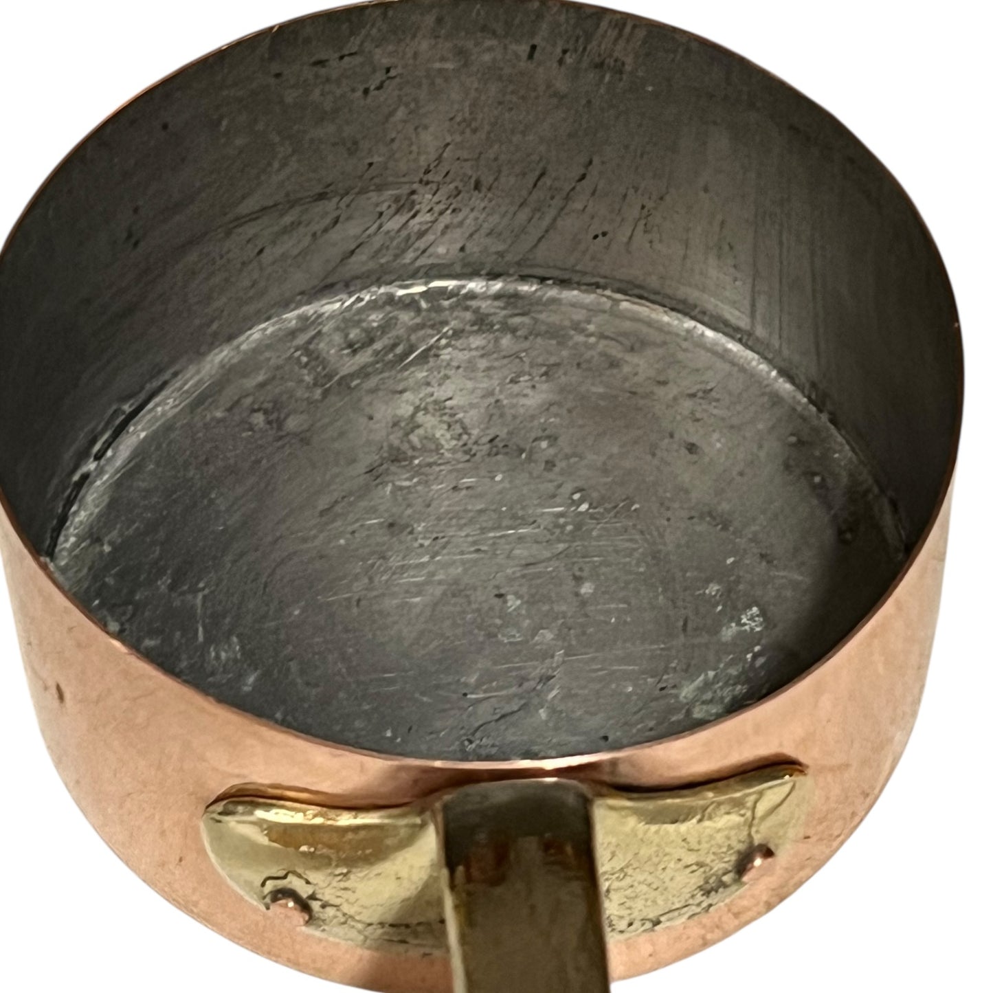 Close-up of a copper pot with a brass handle and tin lining on a white background