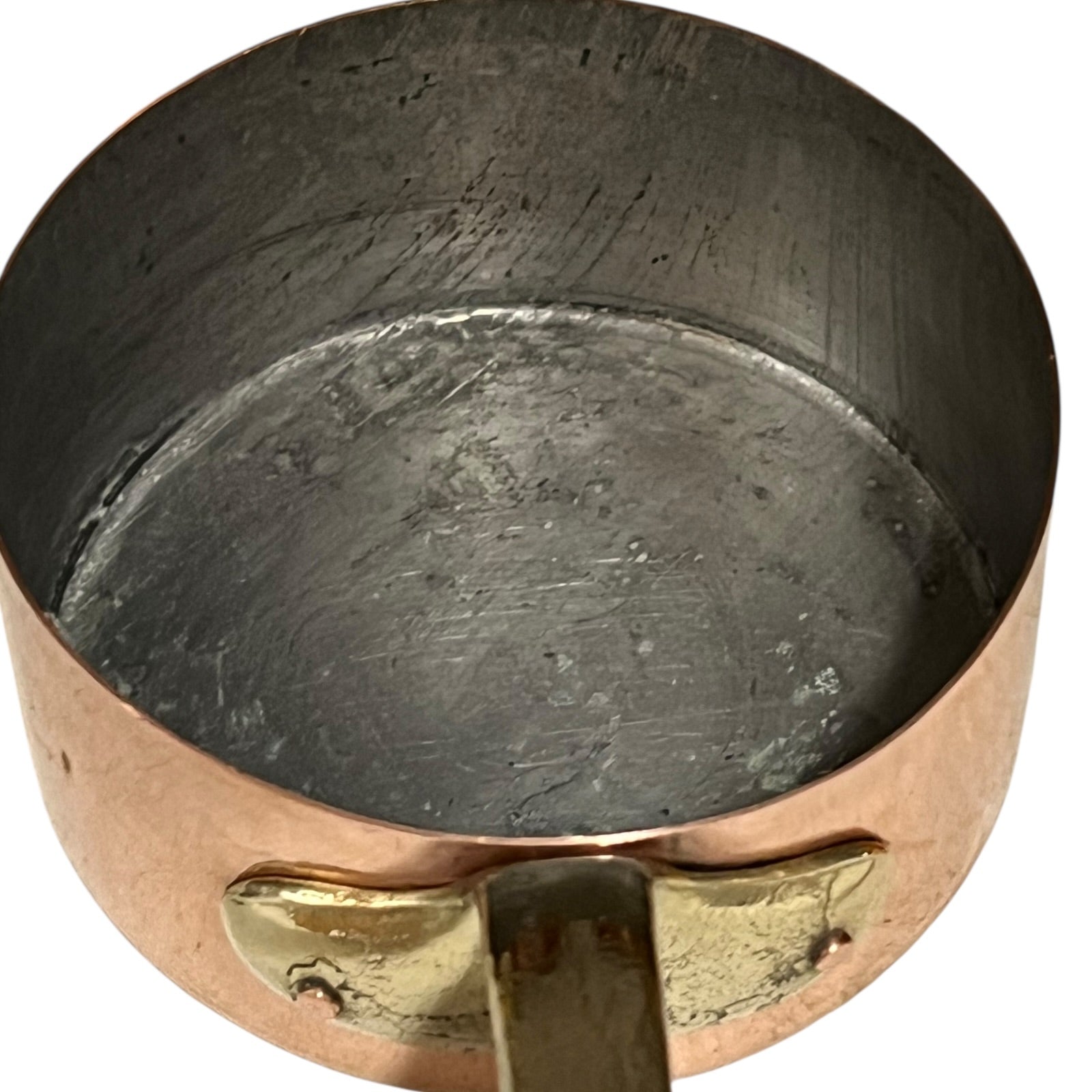 Close-up of a copper pot with a brass handle and tin lining on a white background