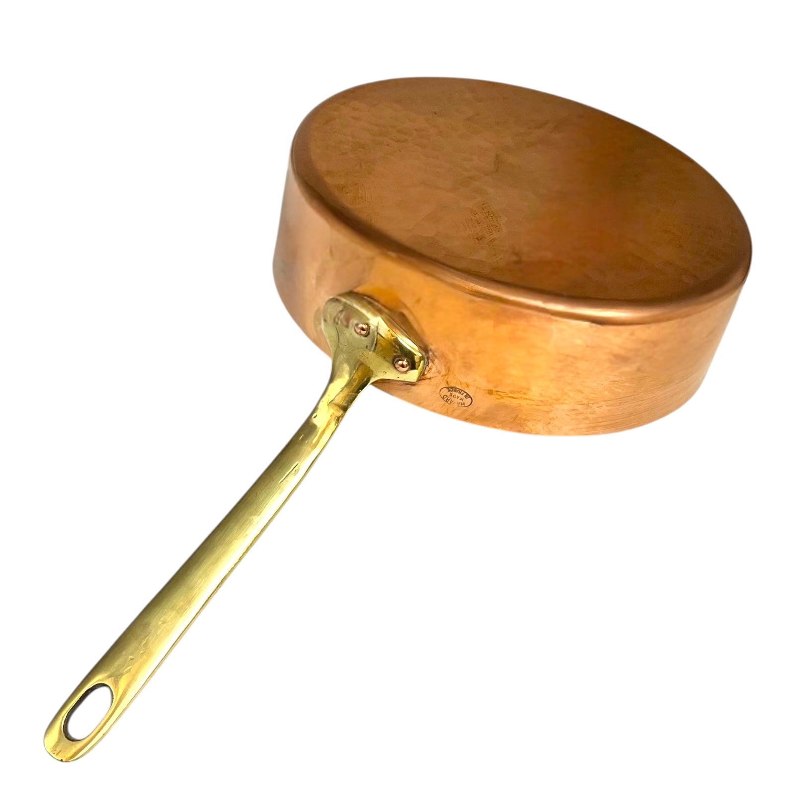 Copper frying pan with brass handle on a white background