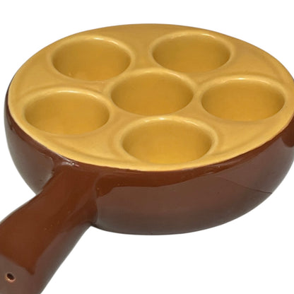 brown ceramic escargots dish with handles and a pale interior, on a white background.