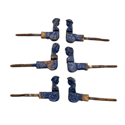 6 French cast iron shutter dogs painted blue with signs and age and wear on a white background