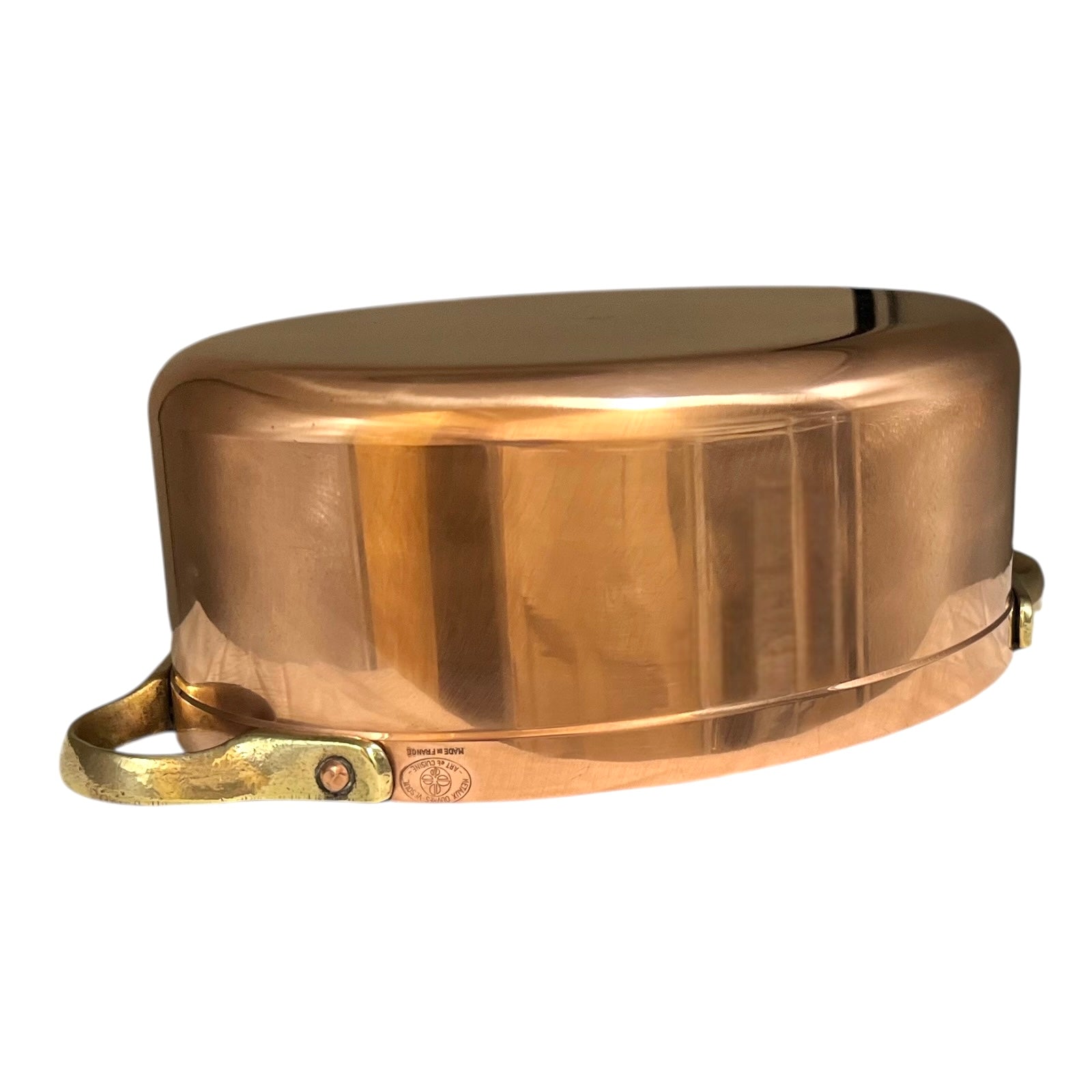 Close-up of a copper lid with a handle on a copper casserole pot