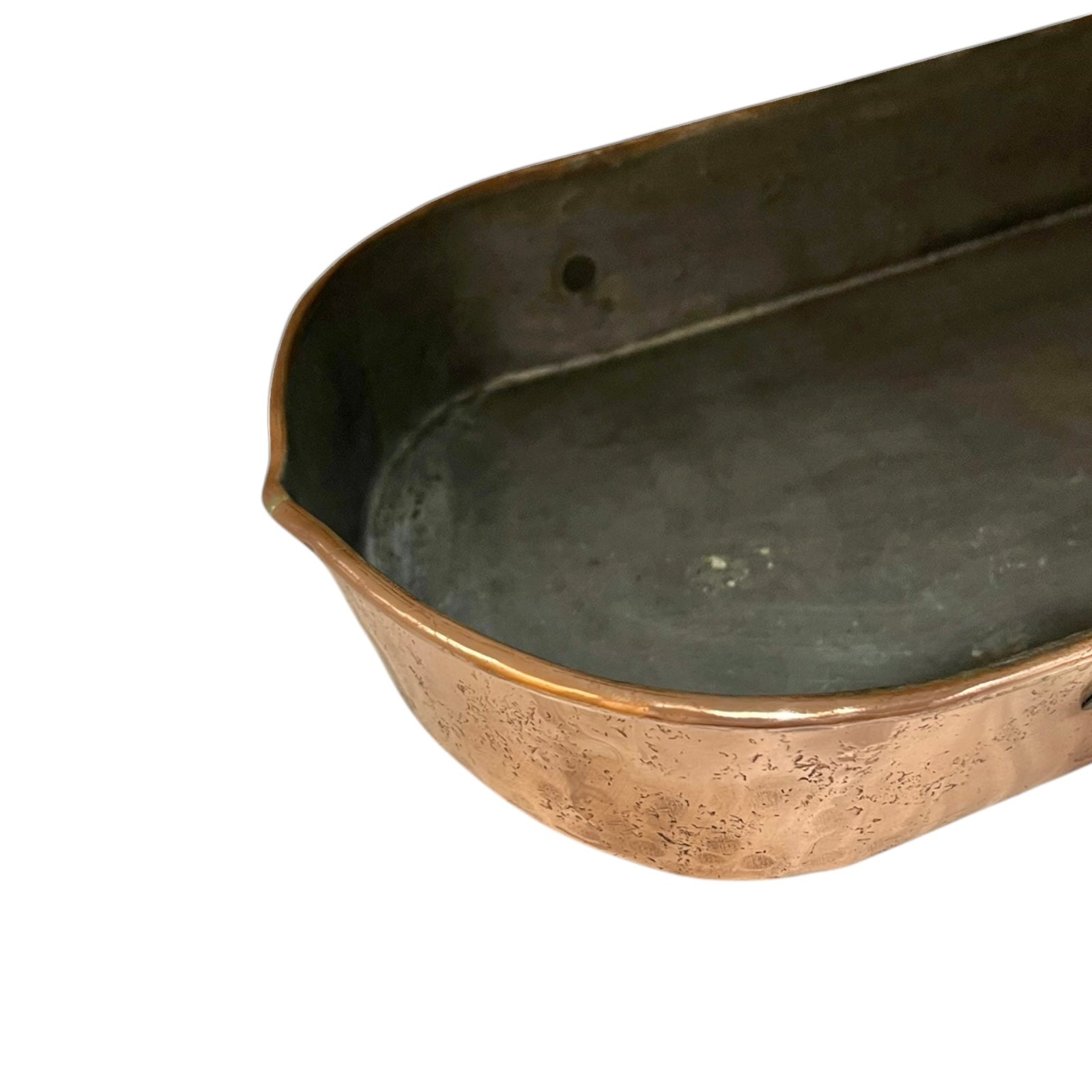 Close up of a copper roasting pan with a long handle on a white background