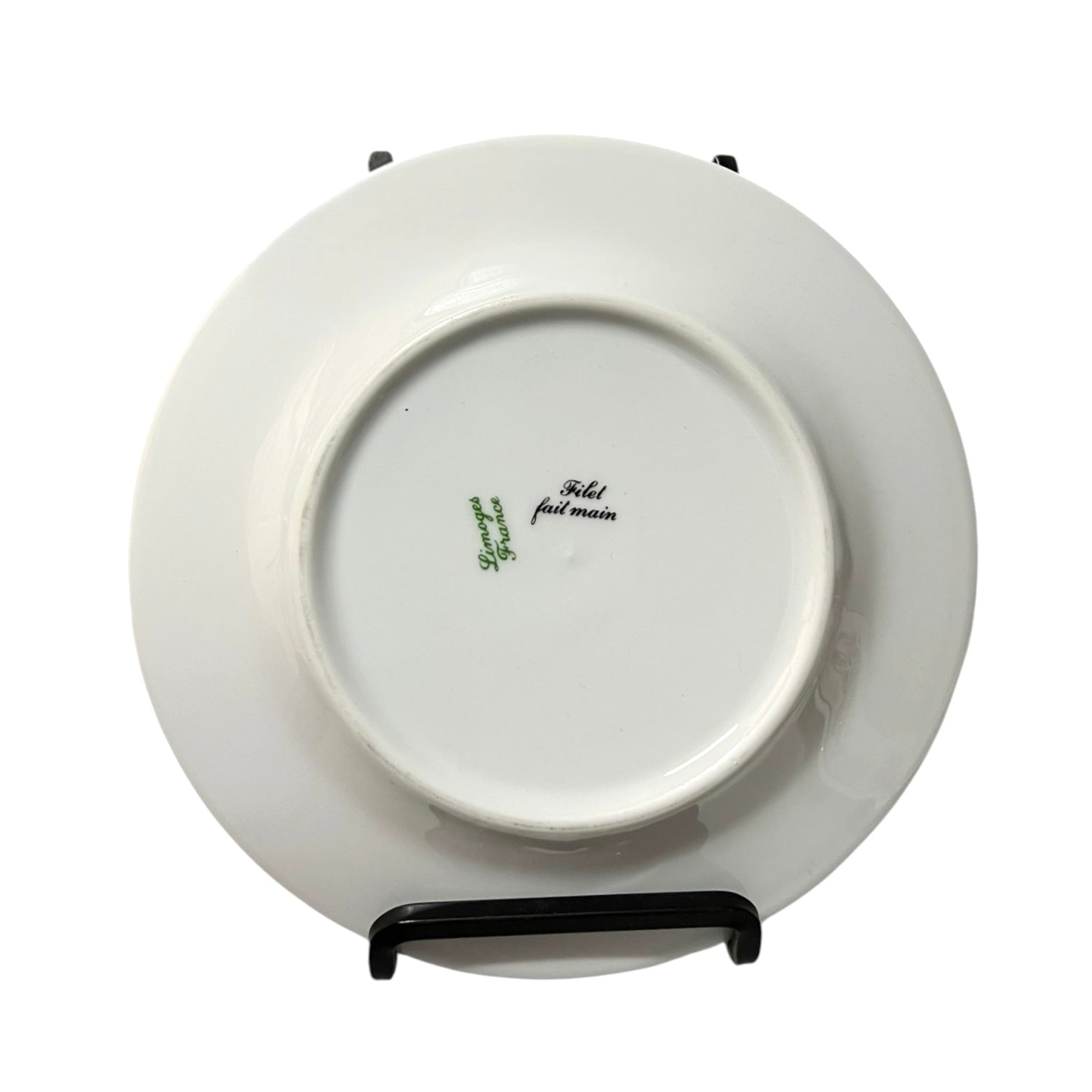 White ceramic plate with branding on a stand against a white background