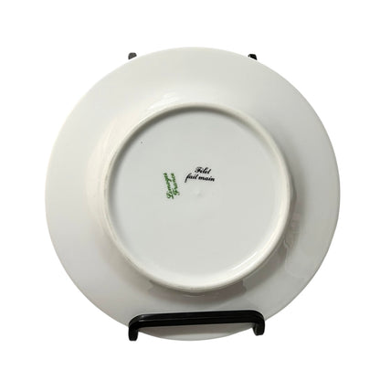 White ceramic plate with branding on a stand against a white background