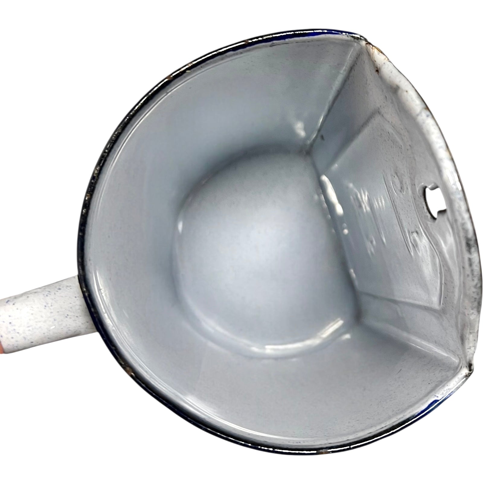 Close-up of the inside of an enamel planter with speckled glaze and blue rim on a white background