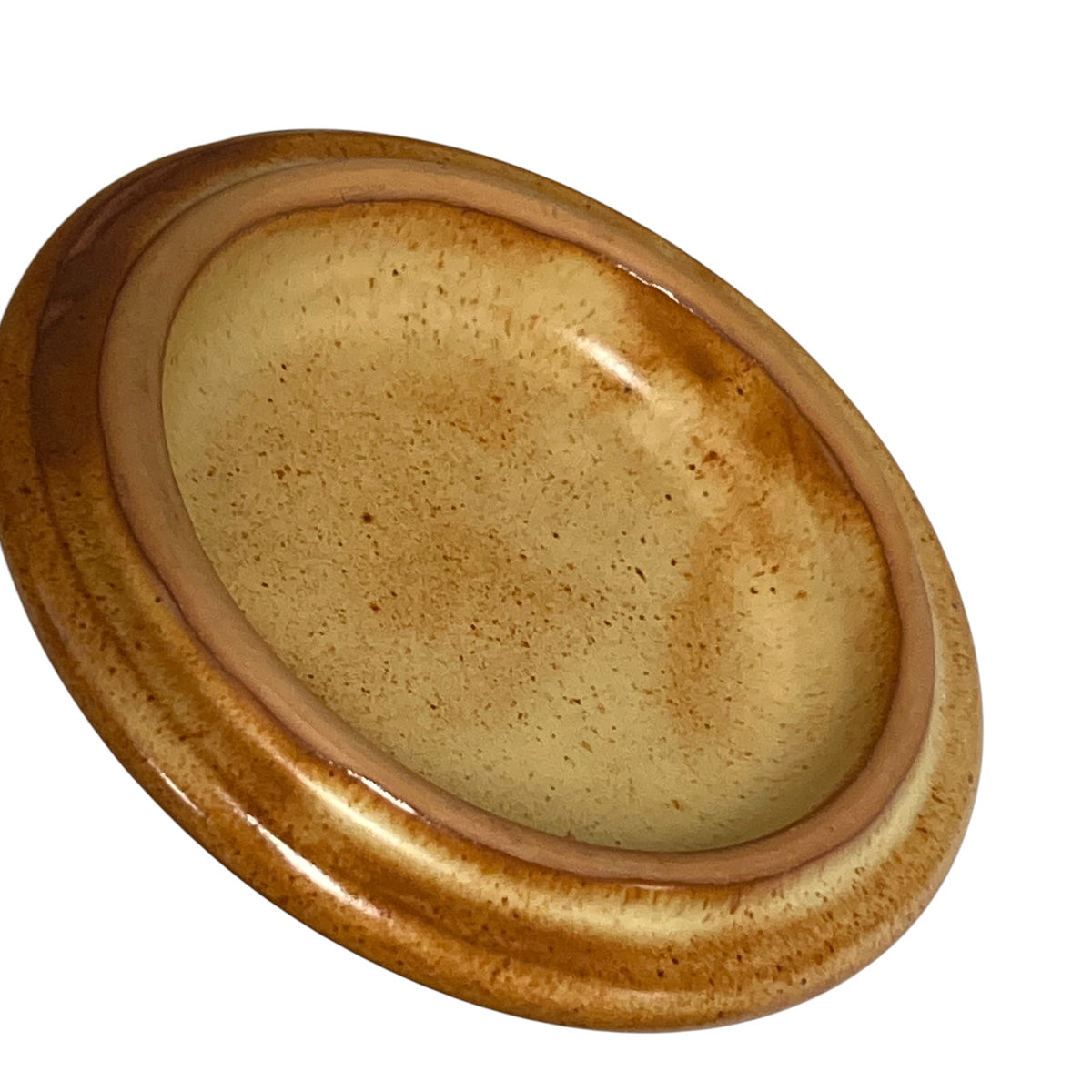 An oval ceramic lid with a glossy, speckled glaze in shades of brown and beige, shown on a plain white background.