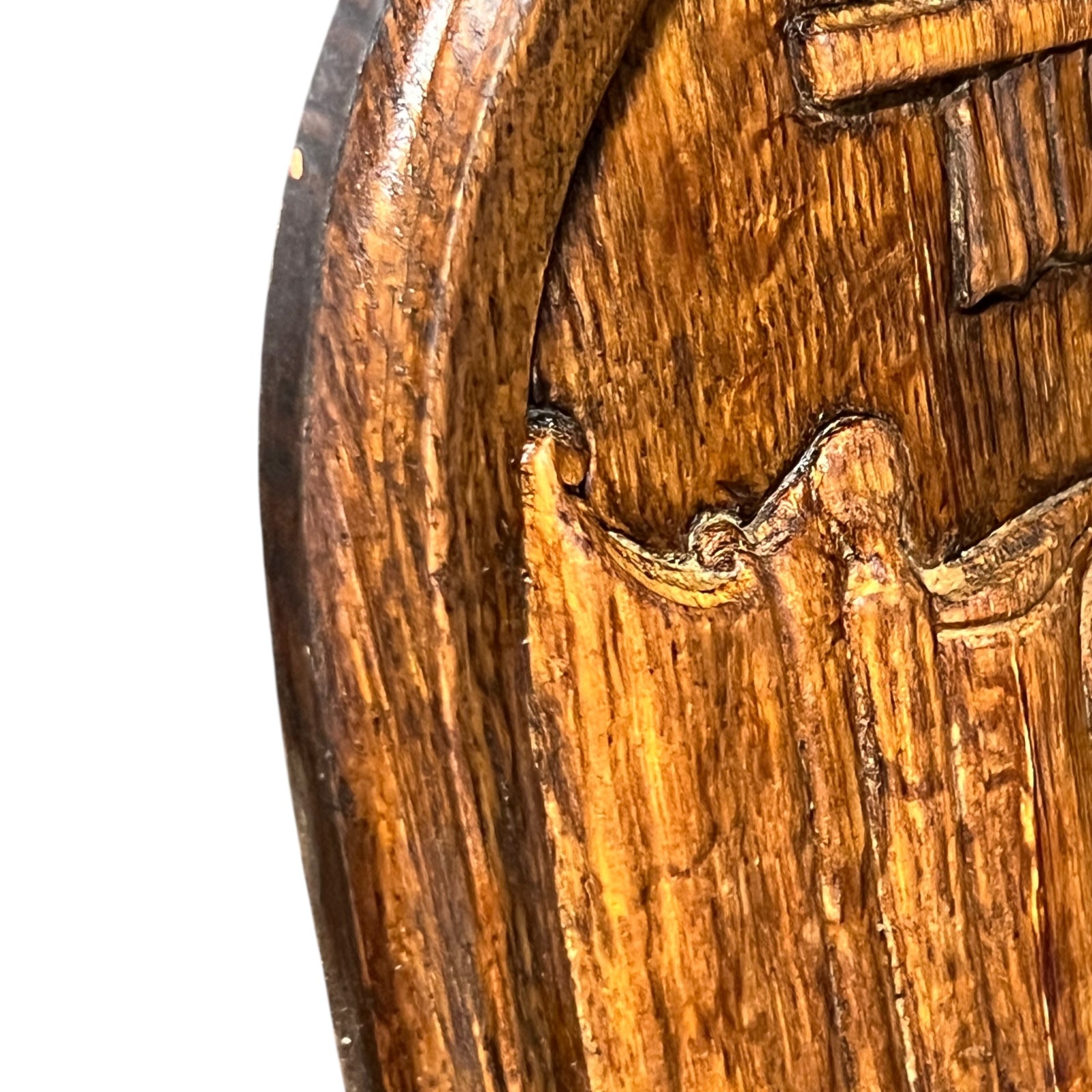 Close-up of a wooden object with intricate carvings on a white background