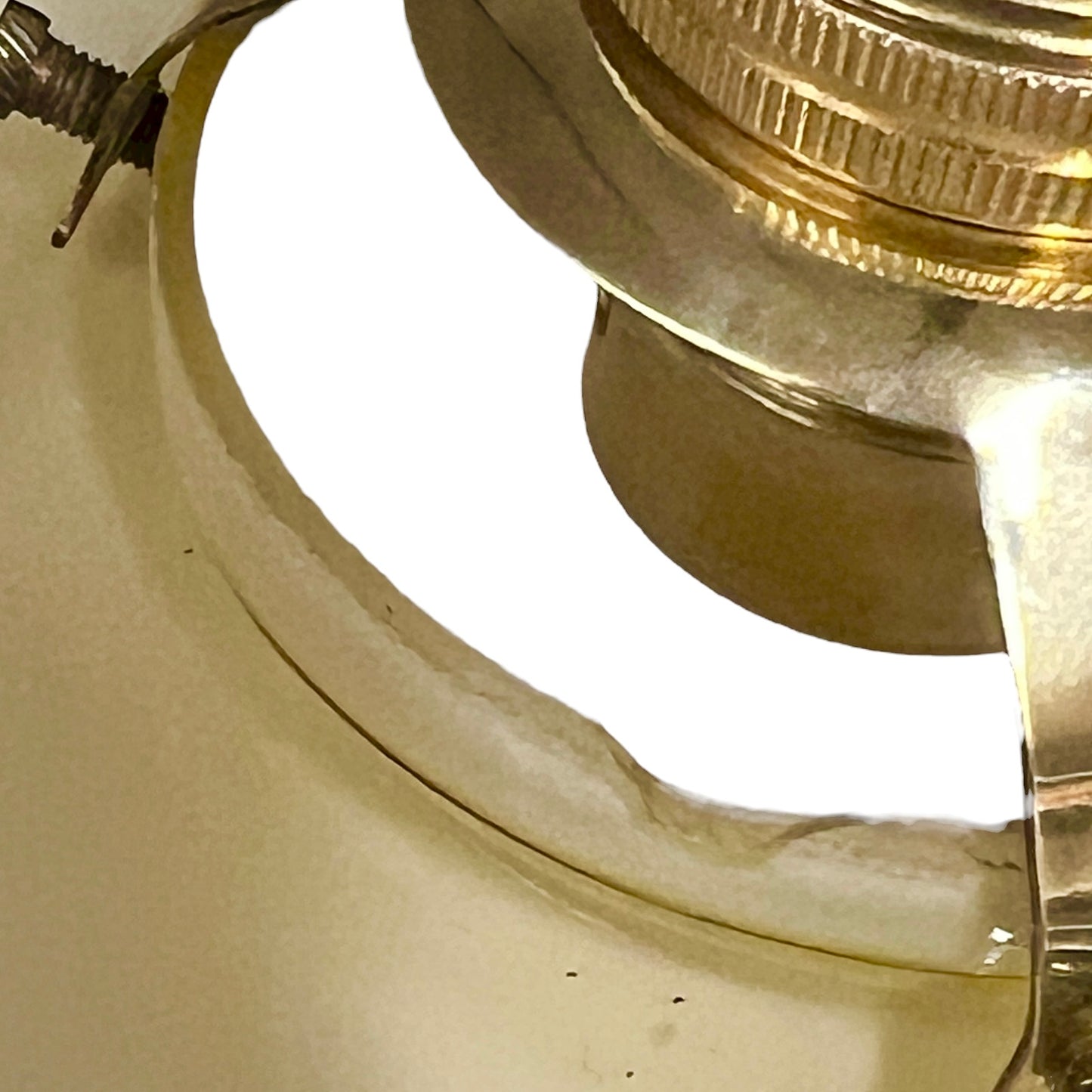 Close-up of a brass lamp fixture on a yellow glass shade