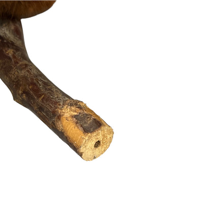 A close-up of a natural brown wooden stick centre hole, shown against a plain white background.