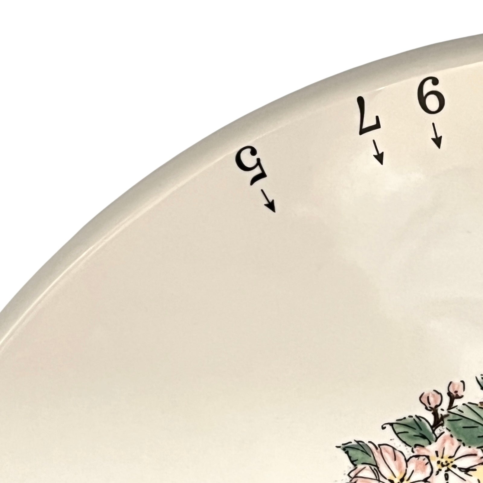 Close-up of a tart platter with floral design and numbers.