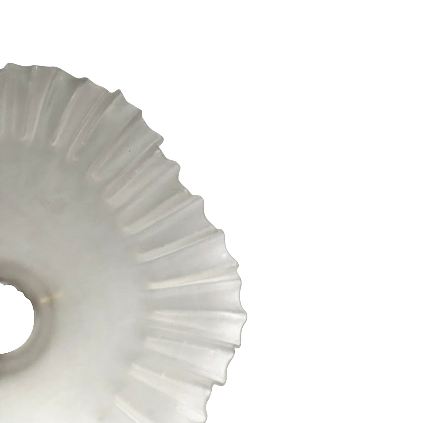 Close-up of a glass lamp shade with a scalloped edge on a white background