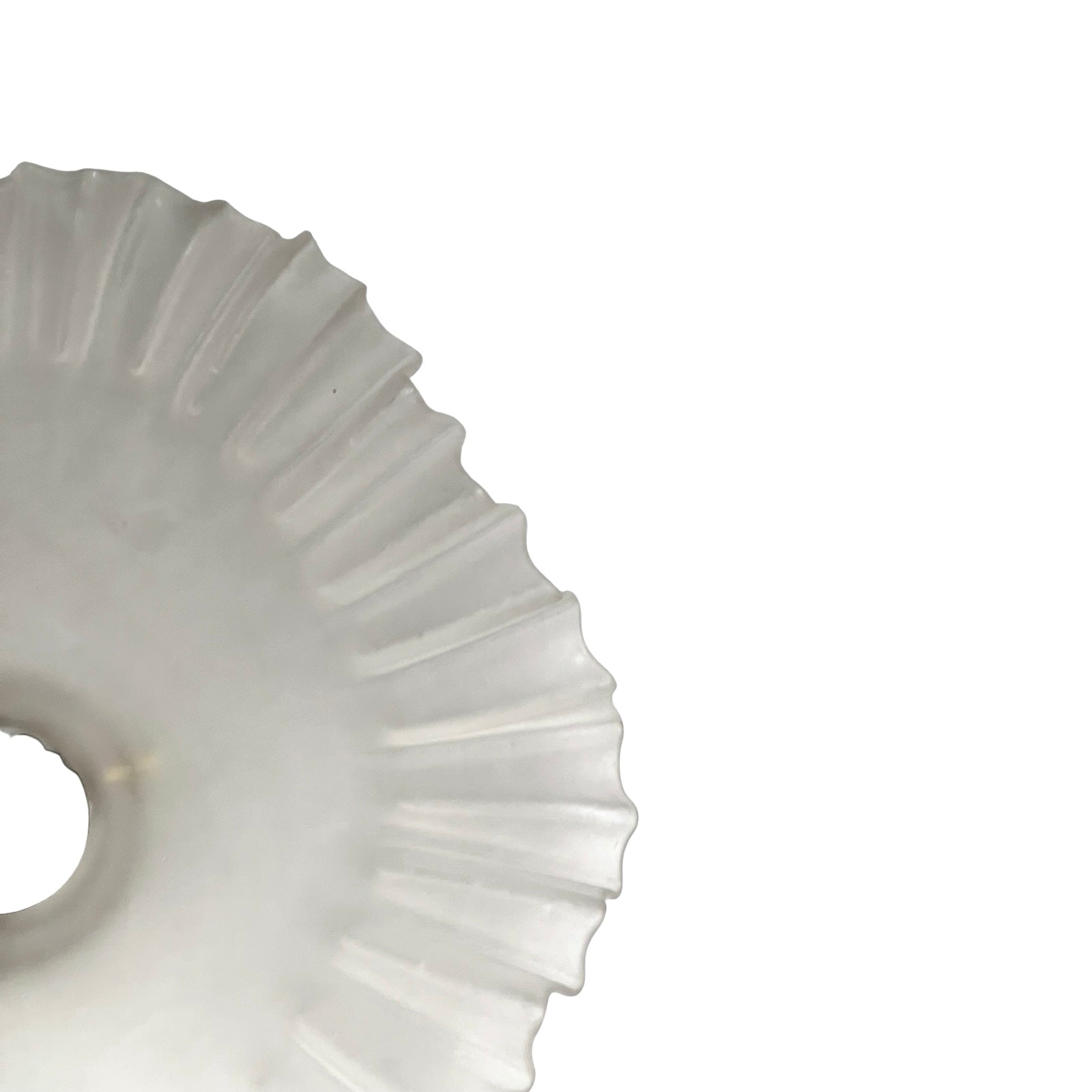 Close-up of a glass lamp shade with a scalloped edge on a white background