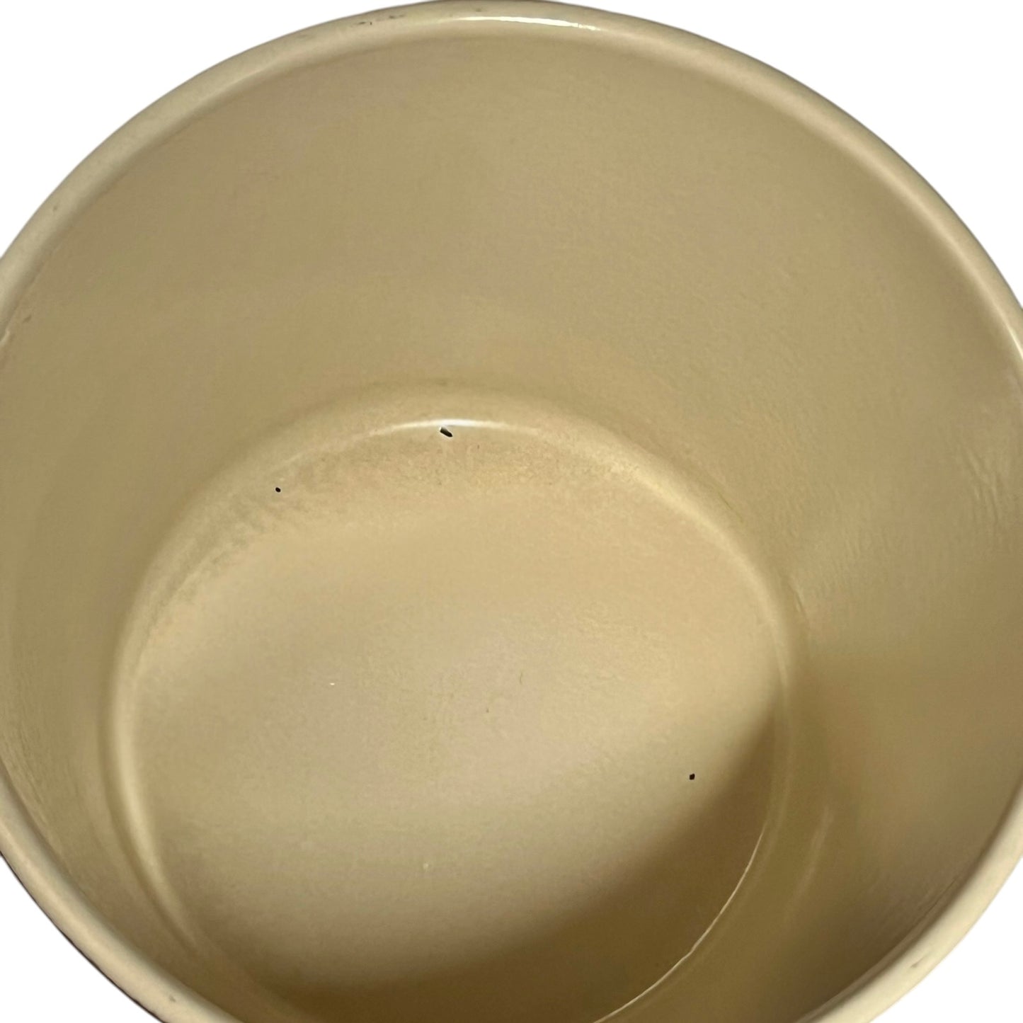 Close up of a rust coloured cast iron saucepan with lid on a white background