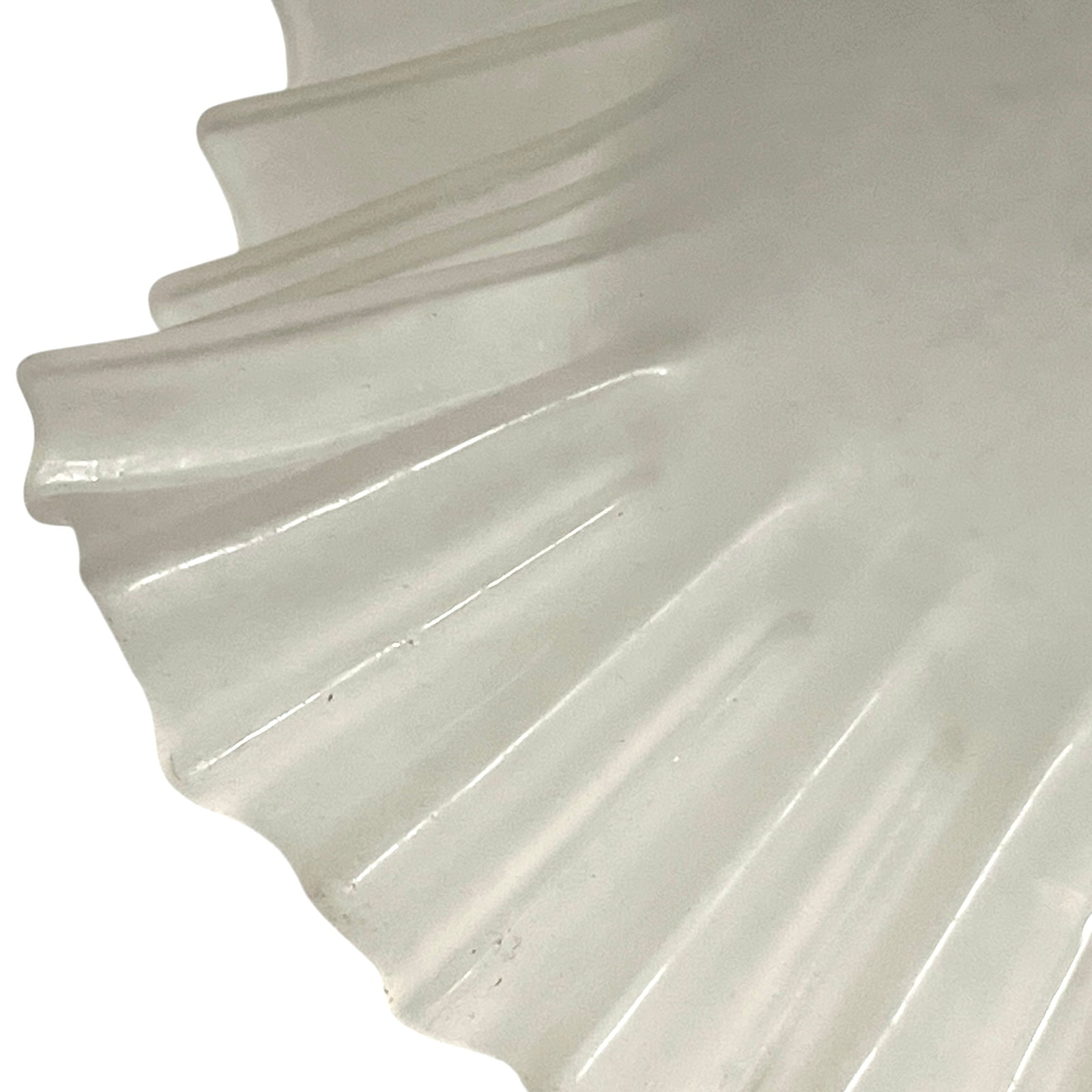 Close-up of a glass lamp shade with a scalloped edge on a white background