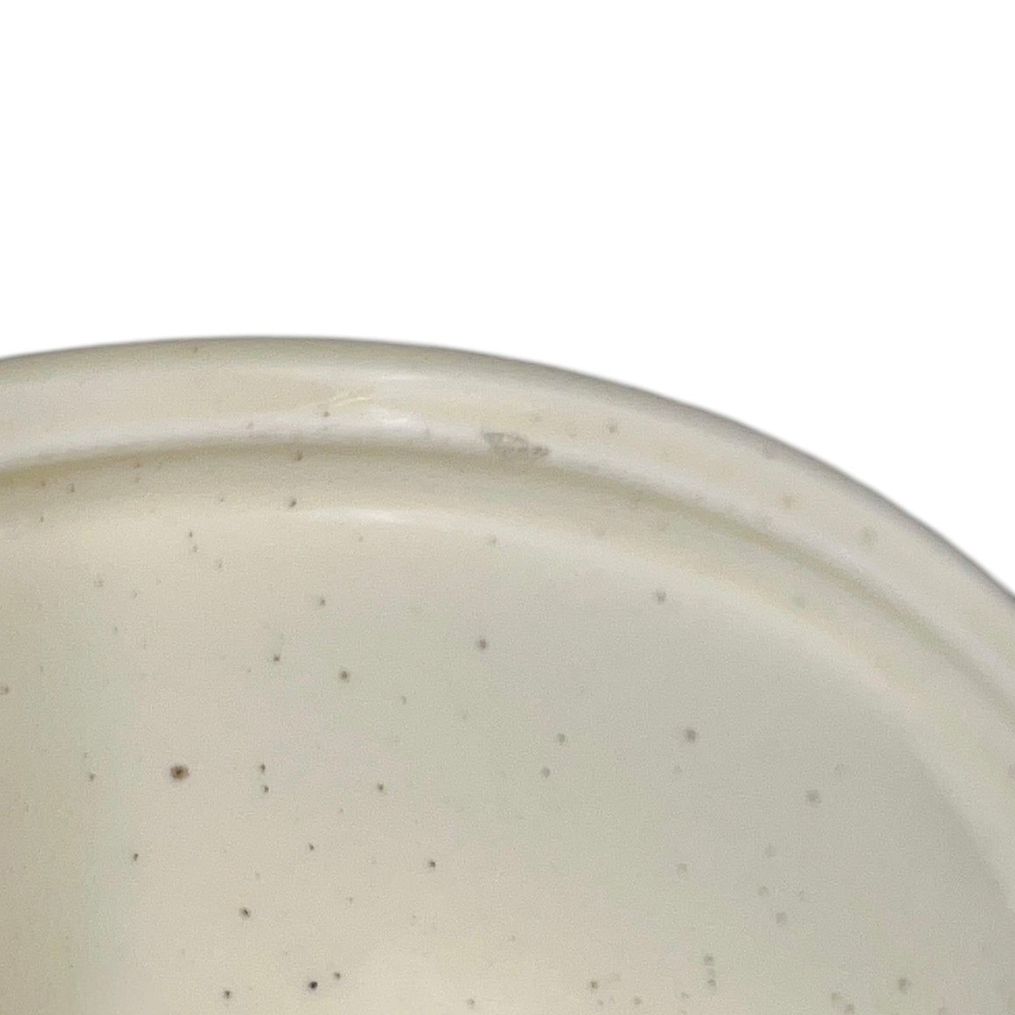 Close-up of a beige ceramic bowl with speckled texture on a white background