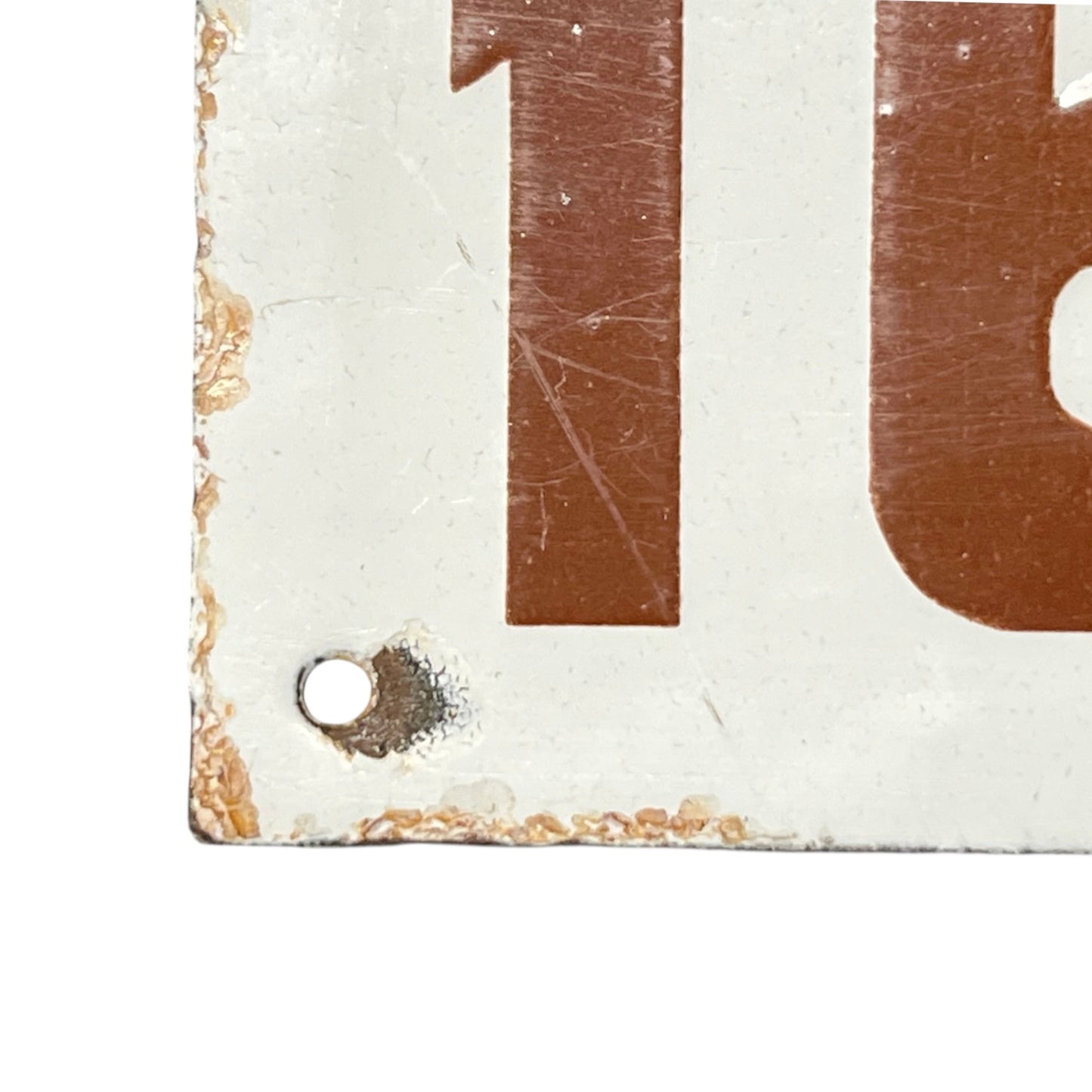 Close-up of a rusted metal sign with the number '162'.