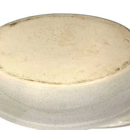 Round ceramic plate with a speckled beige and brown design on a white background