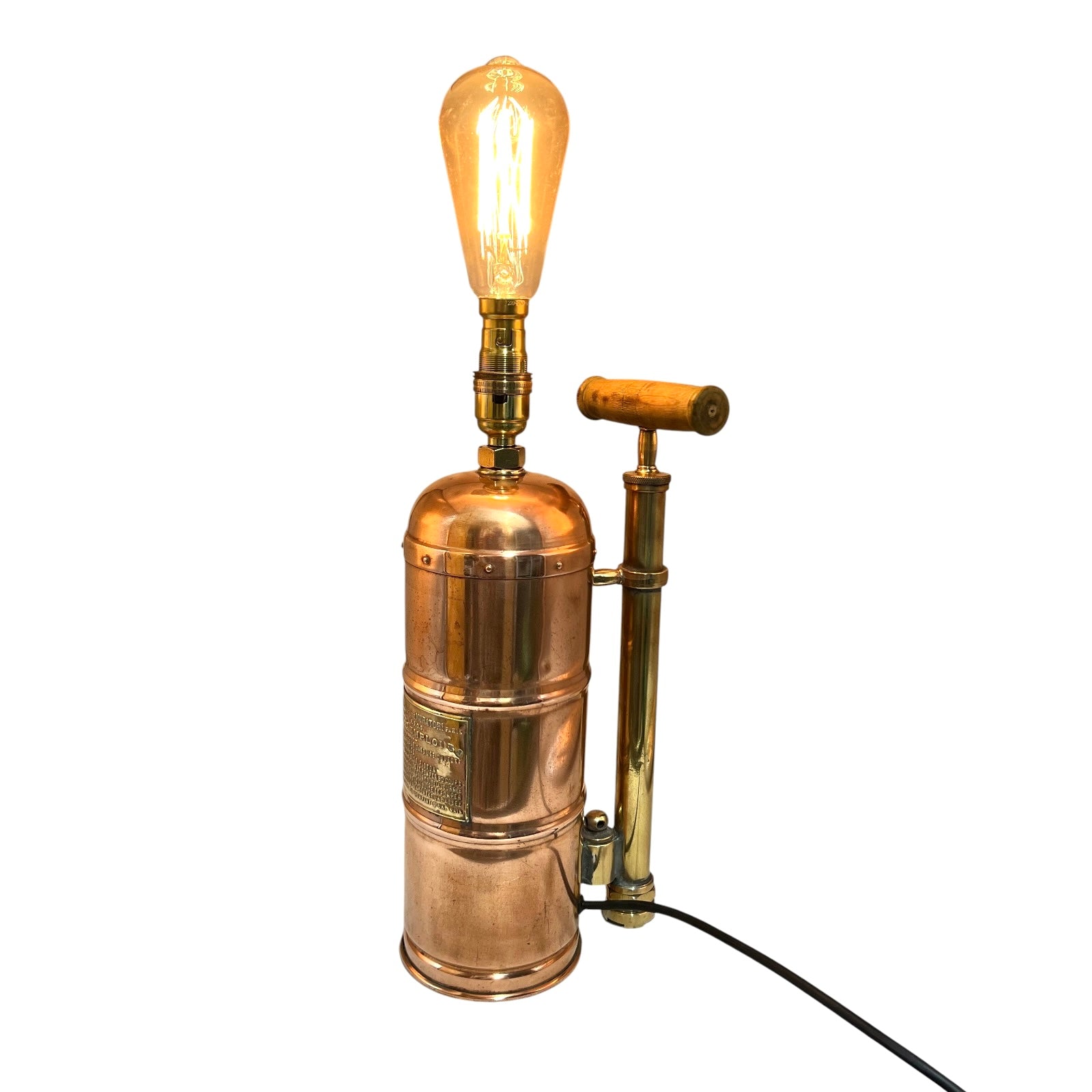 Copper and brass lamp with an exposed bulb on a white background